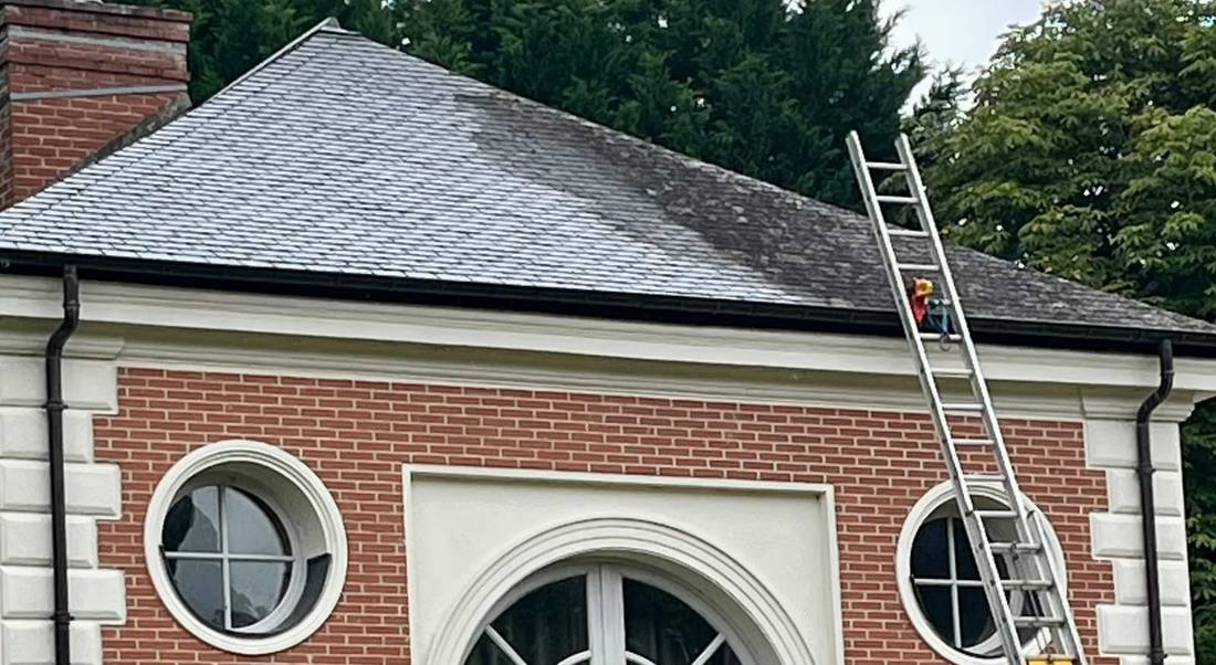 Intervention sur toiture en ardoise d'un bâtiment de brique