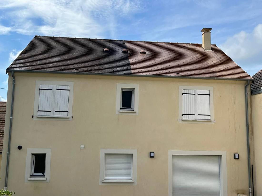 Nettoyage en cours sur la toiture d'une maison beige