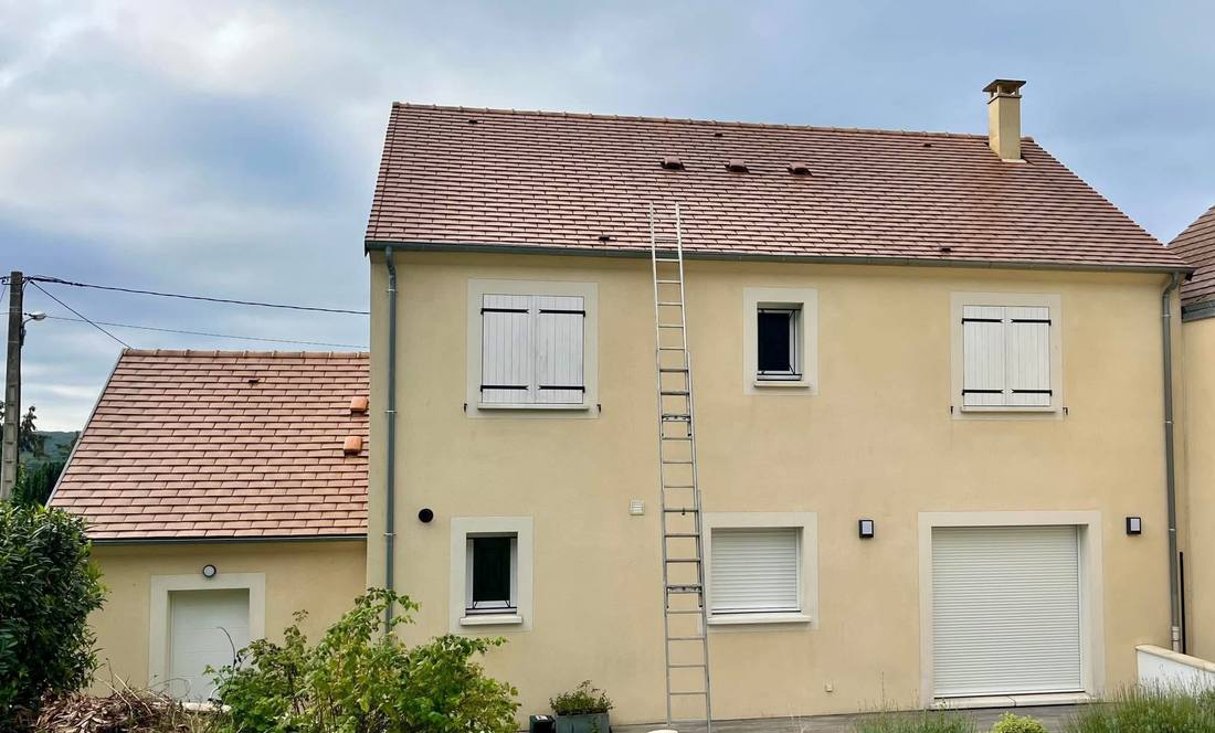 Toiture nettoyée d'une maison en crépi, échelle en place