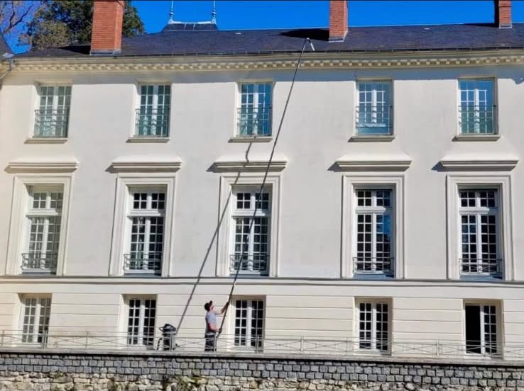 Nettoyage de gouttières à la perche télescopique sur une grande demeure